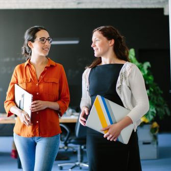 Two colleagues discussing when leaving a presentation meeting