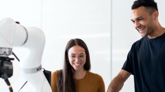 two mechatronic student engineers using robotic arm