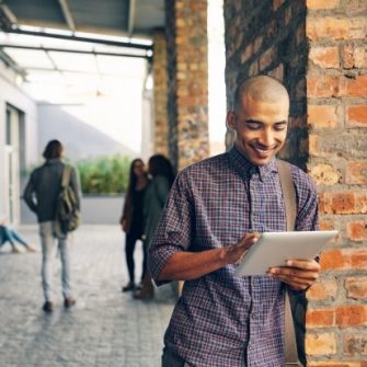 male student leaning against wall