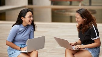 Two students sit together to work through assignments