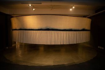 Artwork made of cloth hanging downwards from a circular platform