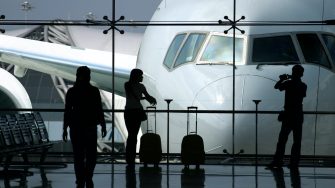 Three people waiting to board an aeroplane