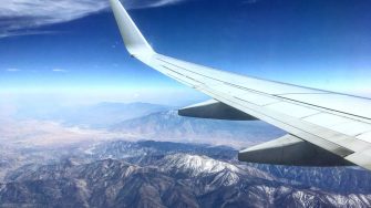 Aeroplane wing over mountains