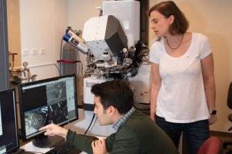 Material scientists in lab assessing results on computer screen