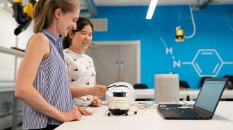 Engineer students with robot and laptop