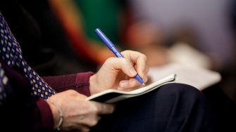 Photograph of someone writing in a book