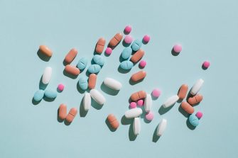 A pregnant woman taking a pill while sitting on her lounge at home