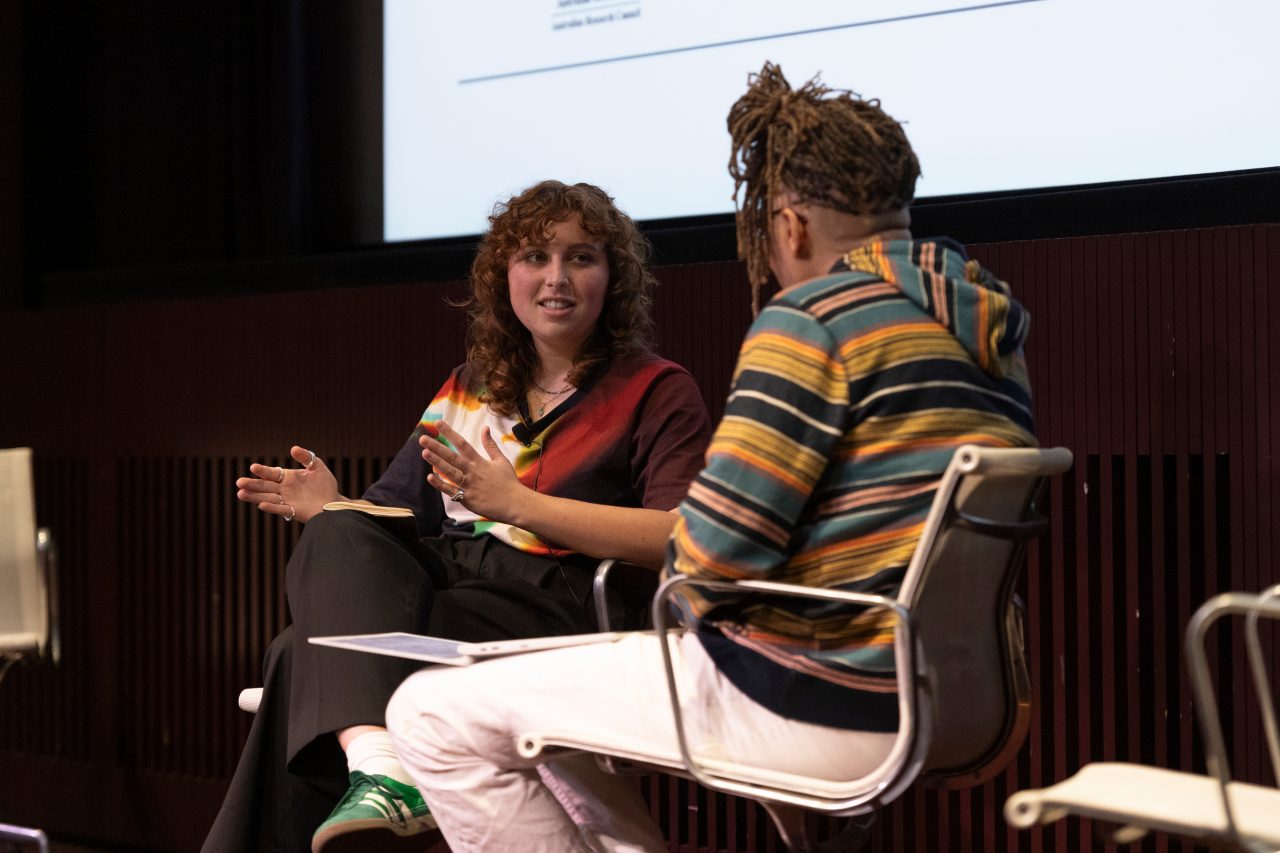 Two people in conversation on stage and smiling