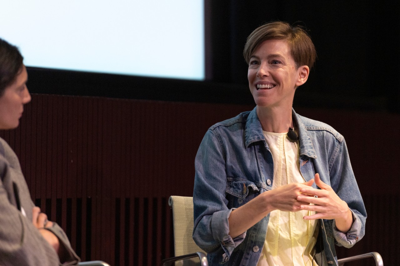 Two people in conversation on stage and smiling