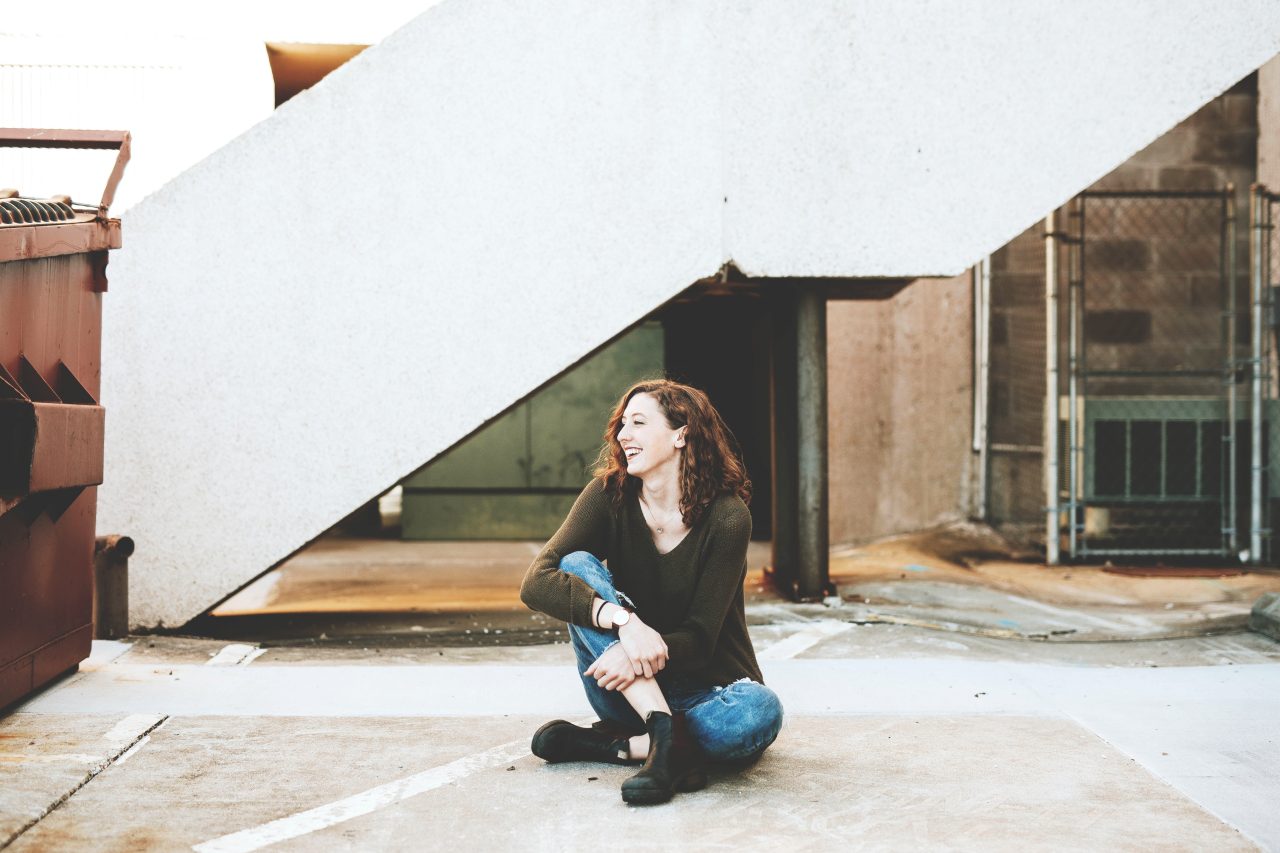 Woman sitting near a concrete staircase